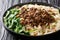 Recipe forÂ dan dan noodlesÂ with minced meat and greens closeup in a plate. horizontal